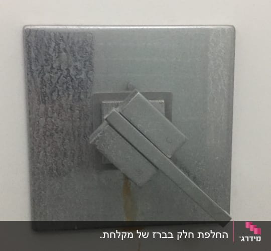 ברז מתכת עם כתמי חלודה על הקיר